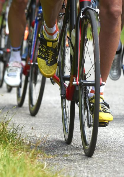 Ciclisti in gara su strada, pedalano con intensità.