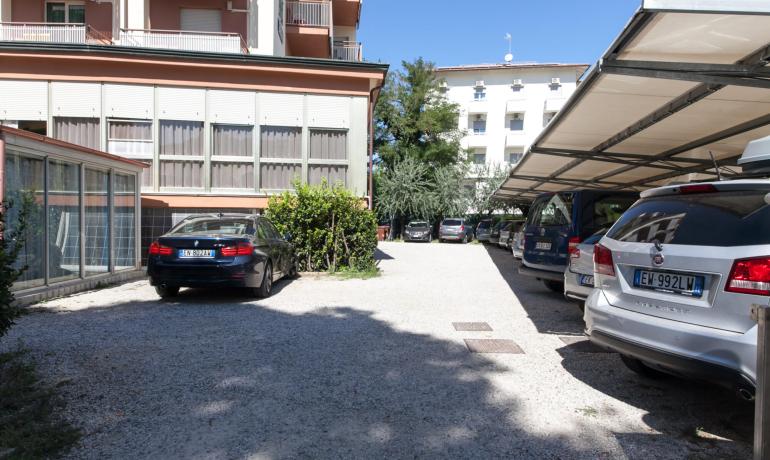 Parcheggio all'aperto con auto vicino a edifici residenziali.